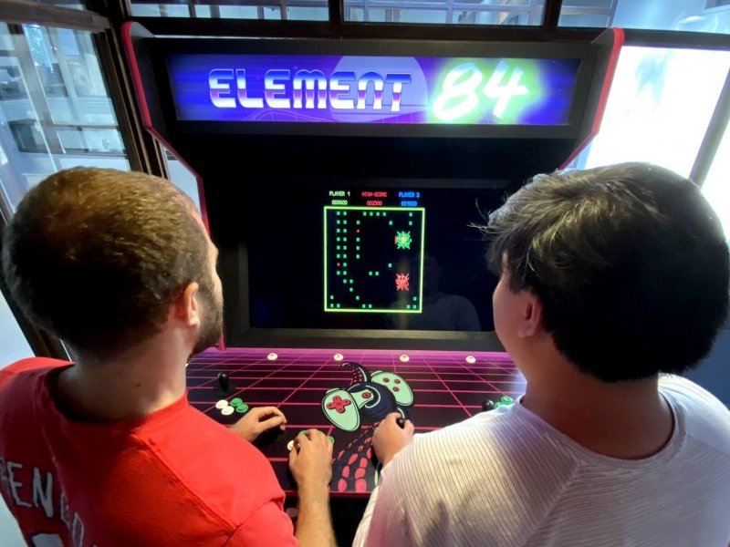 Two men playing games on the Element 84 arcade